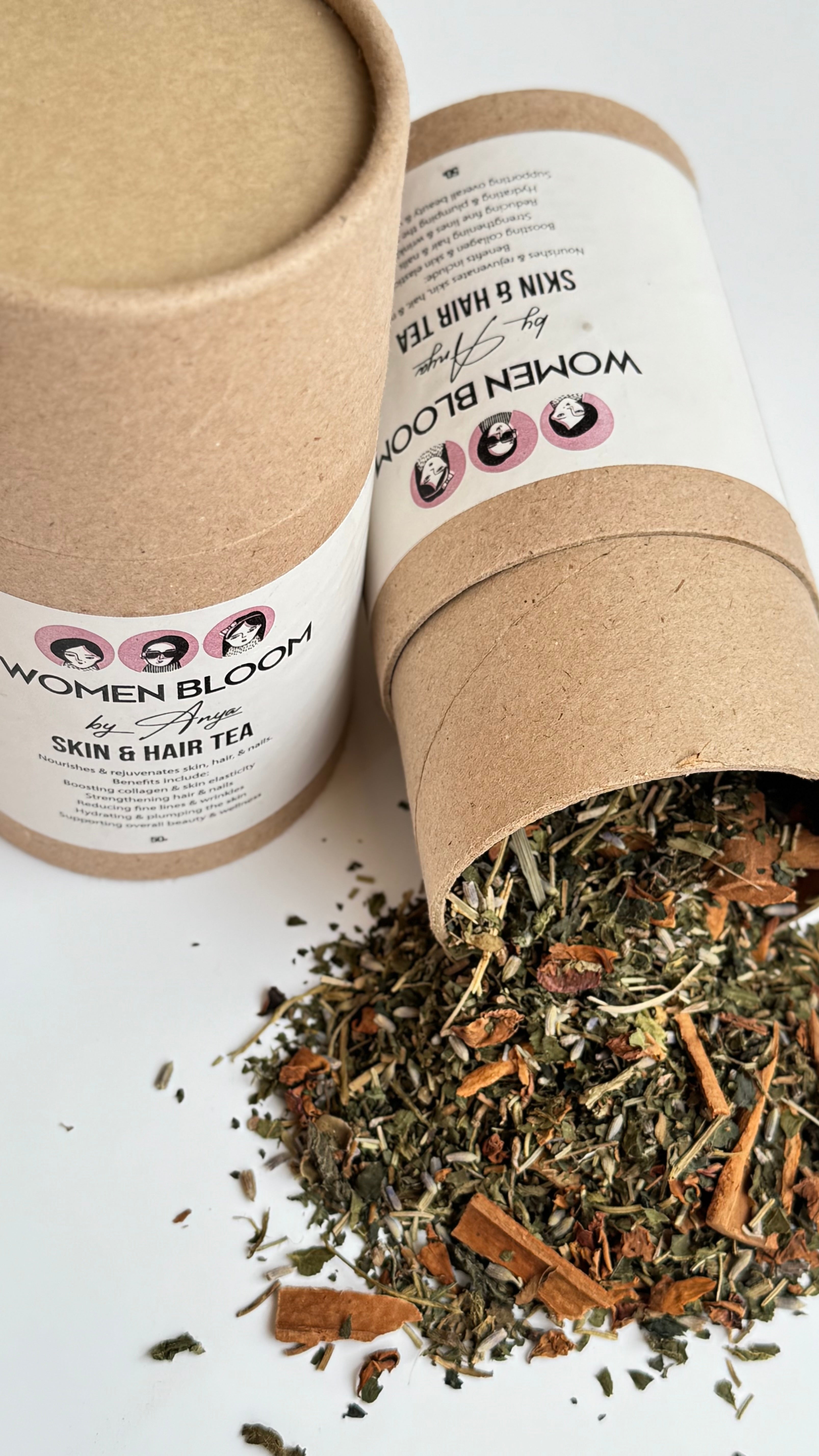 Open cardboard container of Women Bloom skin and hair tea with tea leaves spilling out on a white background.